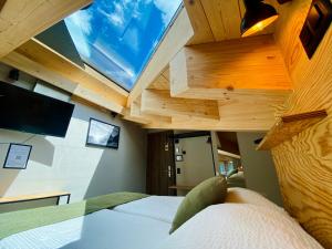 a bedroom with a bed with a ceiling with a window at Peaky Riders Self Check-in Hotel in Zermatt