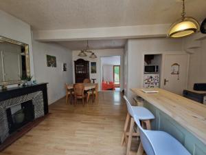 a living room with a fireplace and a table and chairs at Maison au cœur de la cité in Foix
