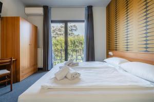 sypialnia z 2 łóżkami i dużym oknem w obiekcie Hotel Al Castello w mieście Torri del Benaco