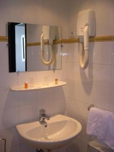 a bathroom with a sink and a mirror at Hôtel Du Centre Annemasse in Annemasse
