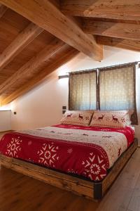 卡斯泰洛泰西諾的住宿－Chalet Grifone - Chalet Maso Vecchio nel cuore del Lagorai Trentino，一间卧室设有一张红色的床和木制天花板