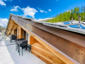 - une vue depuis le toit d'une maison avec une table et des chaises dans l'établissement Peaky Riders Self Check-in Hotel, à Zermatt
