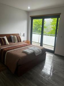 1 dormitorio con cama grande y ventana grande en Casa Gidelos, en Gerês