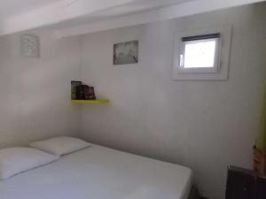 - une chambre avec un lit blanc et une fenêtre dans l'établissement Appartement Port Leucate, 3 pièces, 6 personnes - FR-1-81-47, à Port-Leucate