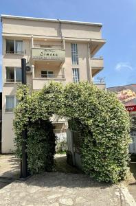 a building with a large bush in front of it at Apartmani Simona in Budva