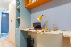 a desk with a laptop and a lamp on it at Student Only, Ensuite-in a Stylish Apartment at Signal Place in Nottingham