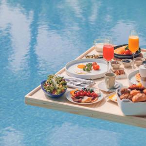 a tray of food on a table next to a pool at Marmarica Boutique Cabana's - Ras El Hekma - North Coast in Marsa Matruh
