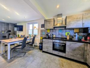 a kitchen with a table and a dining room at Premiumferienhaus Anni in Hasselfelde