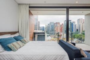 une chambre avec un lit et une grande fenêtre dans l'établissement FL Residence, à São Paulo 291 autres photos