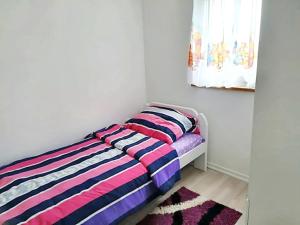 a bedroom with a bed with a colorful striped blanket at 3 bedrooms apartement with furnished garden and wifi at Rakovica in Rakovica