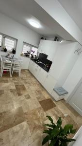 a kitchen with white cabinets and a table in a room at Vila Theo in Mangalia