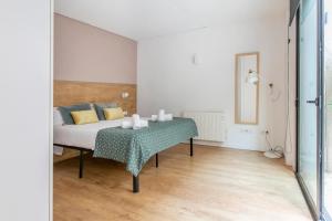 Schlafzimmer mit einem Bett mit einem Tisch und einem Spiegel in der Unterkunft Chic and Modern Apartments in Gracia in Barcelona