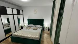 a bedroom with a bed with a green chair at Vila Theo in Mangalia