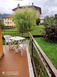 Un patio con una mesa y sillas en un balcón. en La casa di Nonna Mimì, en Abbadia Lariana