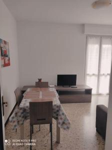 Habitación con mesa, sofá y TV. en La casa di Nonna Mimì, en Abbadia Lariana