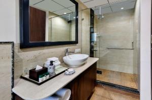 a bathroom with a sink and a shower at ocaen Suites Near Delhi Airport in New Delhi