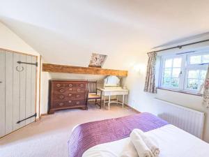 a bedroom with a bed and a desk and a window at The Snug, Beautiful Country Retreat in Priston