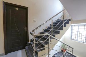 uma escada numa casa com uma porta preta em FabExpress D Crescent em Shamshabad