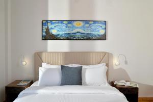 Stork Apartments في فيفاري: غرفة نوم بسرير مع لوحة على الحائط