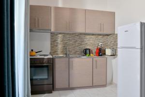 uma cozinha com armários de madeira e um frigorífico branco em Stork Apartments em Vivári