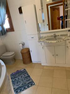 łazienka z umywalką, toaletą i lustrem w obiekcie Villa Alexandra Calpe w mieście Calpe
