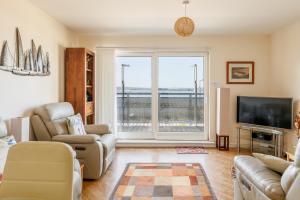 un soggiorno con una grande finestra e una TV di Ahoy a Poole