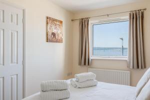 een slaapkamer met een bed en een raam bij Ahoy in Poole