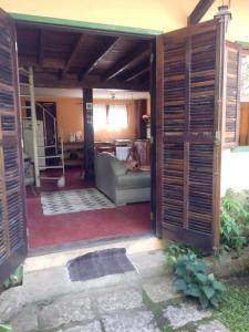an open door into a living room with a couch at Chalé Maringá in Bocaina de Minas