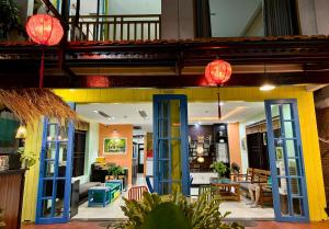 a building with blue and yellow doors and lights at Pearl Beach Homestay - Cua Dai Beach, Hoi An in Hoi An