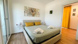 um quarto com uma cama com duas almofadas em Tony Maison - Amazing seaview in a modern apartment em Bari