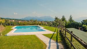 una piscina en un patio con una valla en La Terrazza sul Lago - Italian Homing, en Polpenazze del Garda