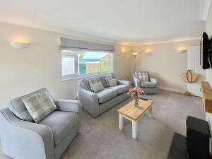 a living room with two couches and a table at Silvershell View in Port Isaac