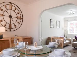 萊瑟姆－聖安妮的住宿－Commonside Cottage，墙上设有大钟的餐厅