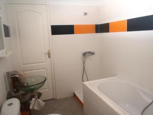 a bathroom with a tub and a colorful stripe on the wall at Grande villa avec piscine et jacuzzi in Terre-de-Haut