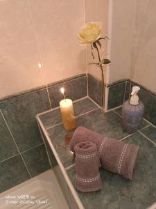 uma vela, uma toalha e uma flor no chuveiro em Luisetta em Massafra