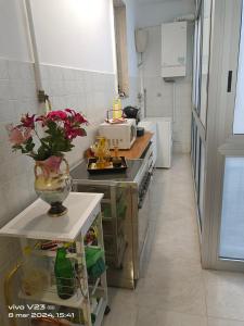 uma cozinha com um vaso de flores num balcão em Luisetta em Massafra