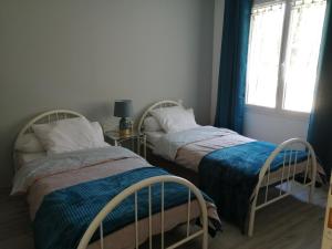 zwei Betten in einem kleinen Zimmer mit Fenster in der Unterkunft Maison proche de Royan à Meschers sur Gironde 2 chambres in Meschers-sur-Gironde