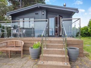 a tiny house with a wooden deck with a bench at Ty Glan Mor the Beach House in Llangoed