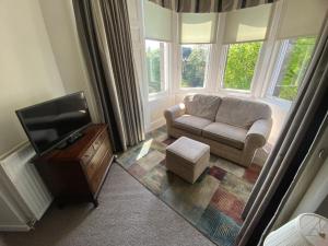 uma sala de estar com um sofá e uma televisão em The Strathearn Hotel em Fife