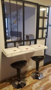 uma mesa e dois bancos em frente a um espelho em Apartamento en Normandia a 10 minutos del aeropuerto em Bogotá