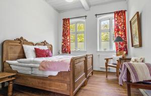 um quarto com uma cama de madeira e 2 janelas em Lovely Home In Haderslev With Kitchen em Haderslev
