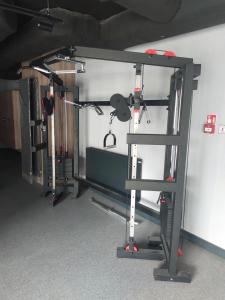 a gym with a squat rack in a room at New Porto in Gdańsk