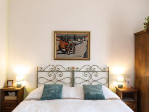 1 dormitorio con 1 cama blanca y 2 almohadas verdes en B&B Casa Decimo, en Greve in Chianti