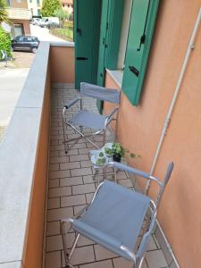 una fila di sedie seduta su un balcone con porta di Casa Ida a Scaltenigo