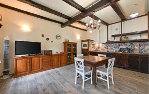 a large kitchen with a wooden table and a television at Beautiful Home In Hlebine With Jacuzzi in Hlebine