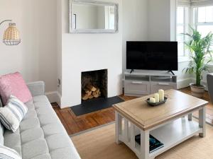 sala de estar con TV y chimenea en Beach View House, en Margate