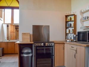 a kitchen with a stove top oven in a kitchen at The Coach House At Waterperry Gardens in Waterperry
