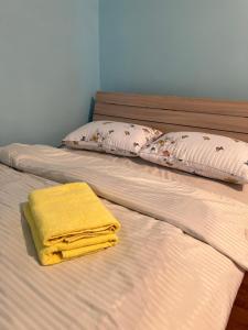 two beds with yellow towels sitting on top of them at Mini hotel in Almaty
