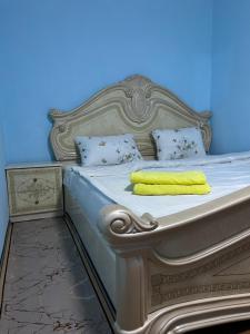 a white bed with a yellow towel on it at Mini hotel in Almaty