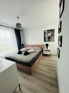 - une chambre avec un lit et une grande fenêtre dans l'établissement Apartament Ultramaryna - Reda Aquapark Lipova Park, à Reda